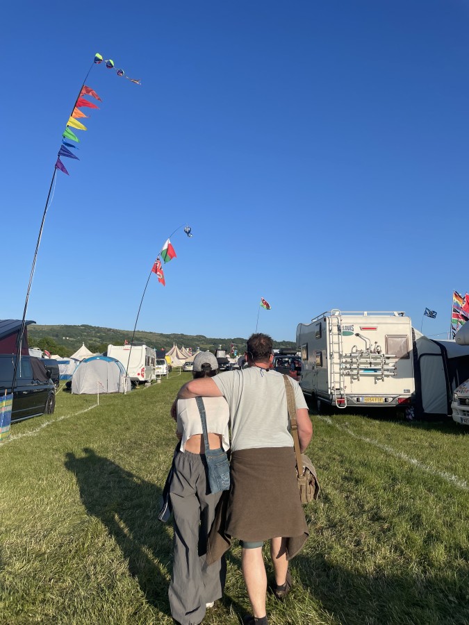 Dad and daughter walking through campsite
